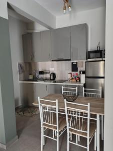 a kitchen with a wooden table and chairs at Vasiliki's apartment in Serres