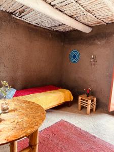 a bedroom with a bed and a table in a room at El hada de Yumbilla in Cuispes