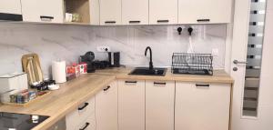 a kitchen with white cabinets and a sink at Alma Apartment - Family Stay Across Aqua Park Raj in Vrnjačka Banja