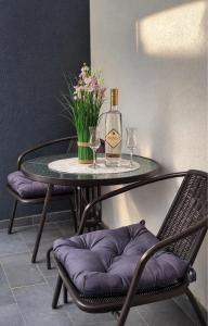 a table with a bottle of wine and two glasses at Alma Apartment - Family Stay Across Aqua Park Raj in Vrnjačka Banja +26 photos