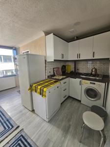 a kitchen with a refrigerator and a washing machine at Royal Konaklama Manzara in Bandırma