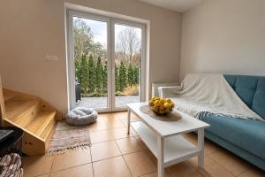 a living room with a couch and a table with a bowl of fruit at Domek na Morskiej in Jantar