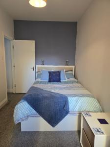 a bedroom with a large bed with blue pillows at Antrim Holiday Apartment in Ramsey