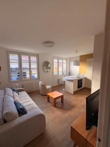 a living room with a couch and a tv at Appartement Moderne & Spacieux - 5 min de la mer in Wimille