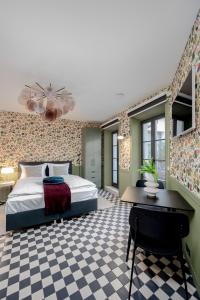a bedroom with a bed and a checkered floor at ROOMA Apartments Boutique Old Town Self Check-in in Vilnius
