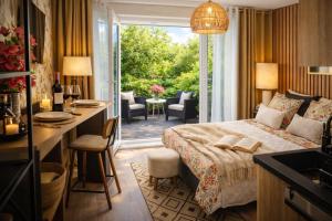 a hotel room with a bed and a desk and a balcony at Petit Cocon des Rives Proche Stanislas-terrasse & parking gratuit in Nancy