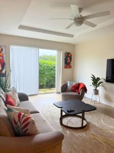 a living room with a couch and a table at Walk to Mullins Beach Ground Floor Pool Fast WiFi in Saint Peter