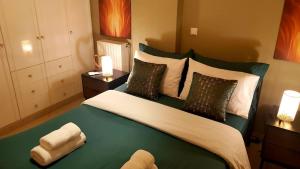 a bedroom with a large green bed with two lamps at Ntarmos Apartment in Sparta
