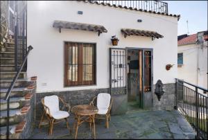 a patio with two chairs and a table in front of a house at House Le Antiche Mura in Castel Volturno