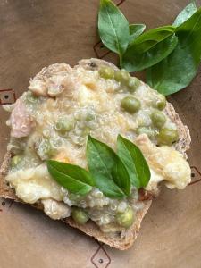 a piece of bread with cheese and green vegetables on it at El hada de Yumbilla in Cuispes +24 photos