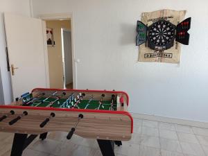 a ping pong table in a room with a dart board at GITE LA NOTARIALE in Combles
