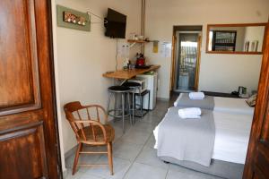 a room with two beds and a table and a chair at Die Aalwyntjie in Riversdale +18 photos