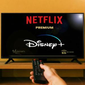 a person holding a remote control in front of a television at 4SEASONS - Amber Spring Suite in Aalborg
