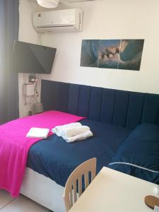 a room with a bed with a pink blanket at Só o Quarto para você! in Rio de Janeiro