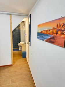 a bathroom with a painting hanging on the wall at Appartamento Osnao in Cefalù +58 photos
