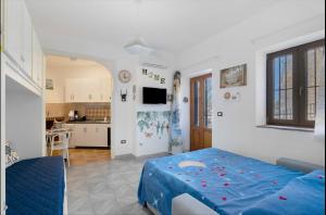 a bedroom with a blue bed and a kitchen at House Le Antiche Mura in Castel Volturno