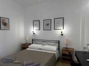 a bedroom with a bed with three pictures on the wall at Happiness Apartment 7 in Sidari