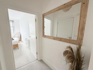 a mirror hanging on a wall in a hallway at Courtyard Retreat in Southampton