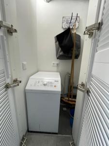 a small laundry room with a white washer and a black bag at Maison Lagune bleue Gruissan in Gruissan