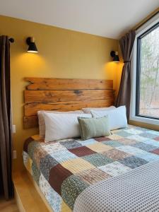 a bedroom with a large bed with a wooden headboard at Bison Farm - Cabin Brisa in Culpeper