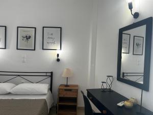 a bedroom with a bed and a desk and a mirror at Happiness Apartment 7 in Sidari