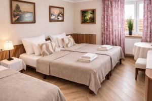 a bedroom with two beds and a couch at Hotelik Zielonka in Zielonka +62 photos