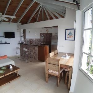 a living room with a wooden table and a kitchen at BLUE HOUSE OCEAN VIEW in Santa Bárbara de Samaná