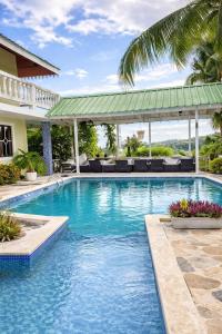 a swimming pool with blue water in a resort at BLUE HOUSE OCEAN VIEW in Santa Bárbara de Samaná