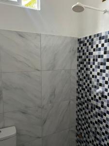 a bathroom with a glass shower with a toilet at Residencial Lourenço - Vila Preá in Cruz
