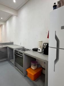a kitchen with a stove and a refrigerator at Residencial Lourenço - Vila Preá in Cruz