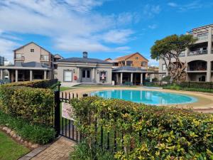 a house with a swimming pool in front of a fence at Heaven at Sea in Mossel Bay