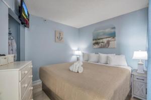 a bedroom with a large bed with white pillows at Carolina Reef #705 in Myrtle Beach +25 photos