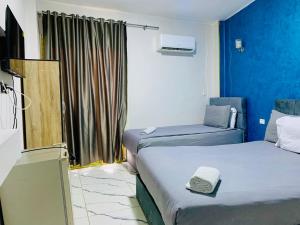 a room with two beds and a tv in it at Nada HOTEL in Cairo