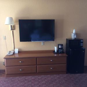 a large television on the wall of a hotel room at DeQueen Courtyard Inn in De Queen
