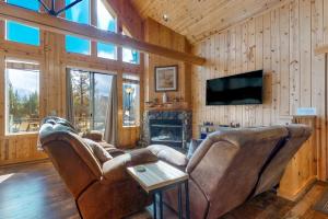 a living room with a couch and a tv at Eagle Creek Chalet on the Pond in Redmond