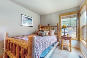 a bedroom with a wooden bed and a window at Eagle Creek Chalet on the Pond in Redmond