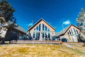 a house with a large porch with chairs on it at Eagle Creek Chalet on the Pond in Redmond