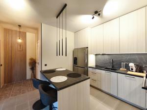 a kitchen with white cabinets and a black counter top at Kusagil Nature & Sauna near Pärnu in Tahkuranna