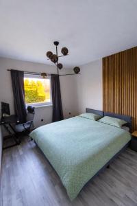 a bedroom with a bed and a desk and a window at Kusagil Nature & Sauna near Pärnu in Tahkuranna