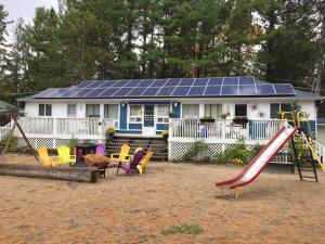 a house with a playground with a slide at Wu Wu's Cabins in Wasaga Beach
