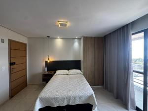 a bedroom with a bed and a desk and a window at STUDIO CALHAU 907 Vista mar in São Luís +24 photos