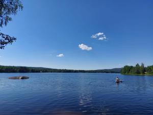 a man is paddling a kayak on a lake at Glamping Tolvsbo Inn in Söderbärke