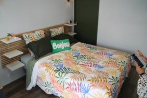 a bedroom with a bed with a colorful comforter at chez laetitia proche du puy in La Flocellière