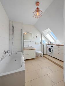 a bathroom with a tub and a sink and a washing machine at Flatista Homes - Herzog Heinrich in Munich +70 photos