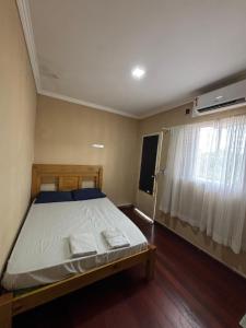 a bedroom with a bed and a window at HOTEL TÊTÊ in Várzea Grande