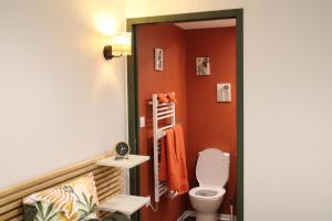 a bathroom with a toilet and orange walls at chez laetitia proche du puy in La Flocellière +10 photos
