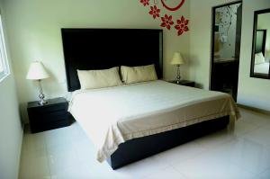 ein Schlafzimmer mit einem großen Bett mit zwei Lampen und einem Spiegel in der Unterkunft Oasis del Sol in Playa del Carmen + 29 Fotos