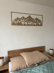 a bed in a bedroom with a picture on the wall at Privat DAŇO in Lisková