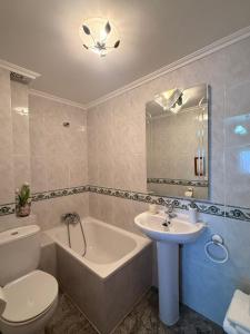 a bathroom with a toilet and a sink and a tub at Casa Rural María Josefa in Bronchales +21 photos