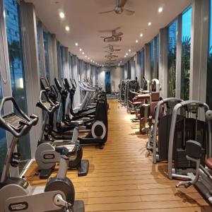 a gym with rows of treadmills and machines at Vortex Apartment klcc by HouseFull in Kuala Lumpur